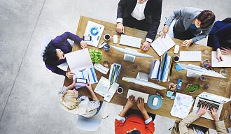 Люди за столом с ноутбуками и документами